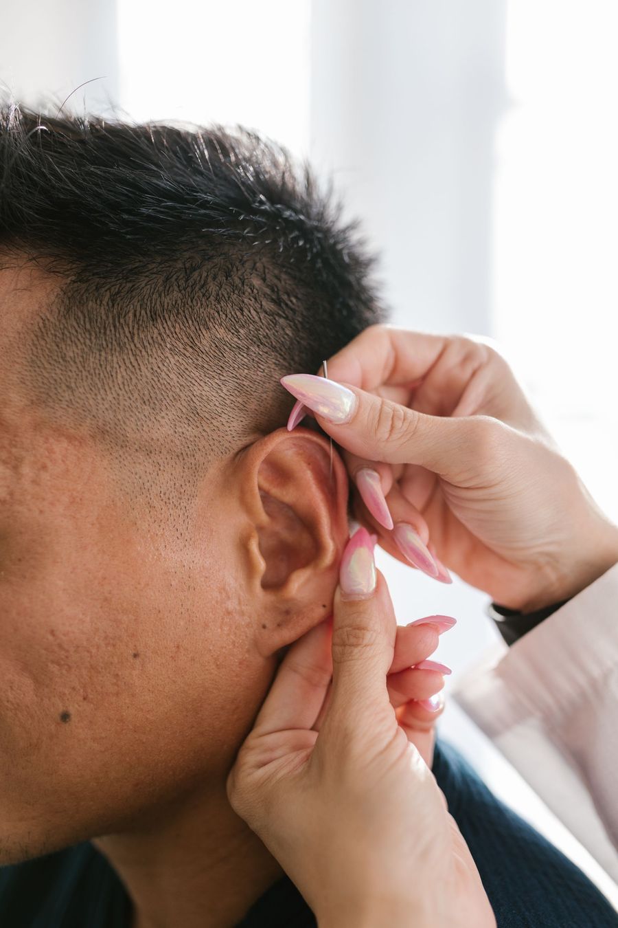 Terapeuta colocando un estímulo en un punto de la oreja
