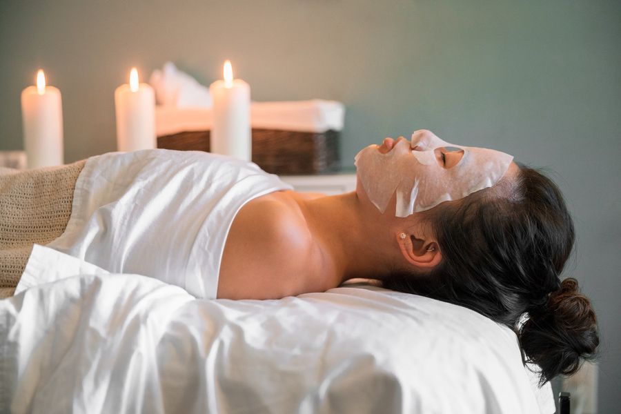 Facial con mascarilla en una cabina con velas