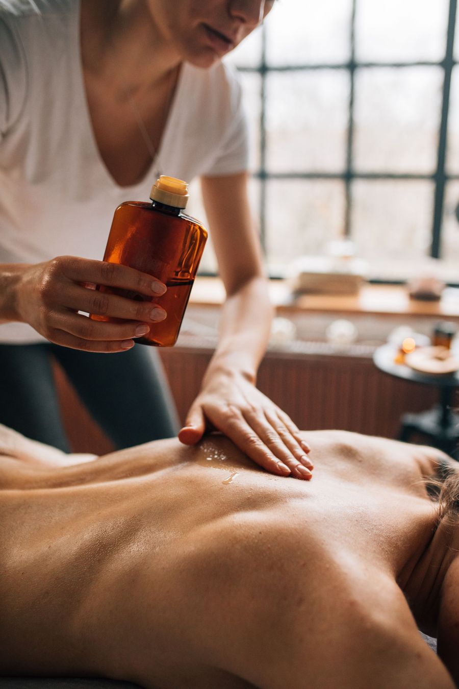 Terapeuta aplicando aceite esencial durante un masaje