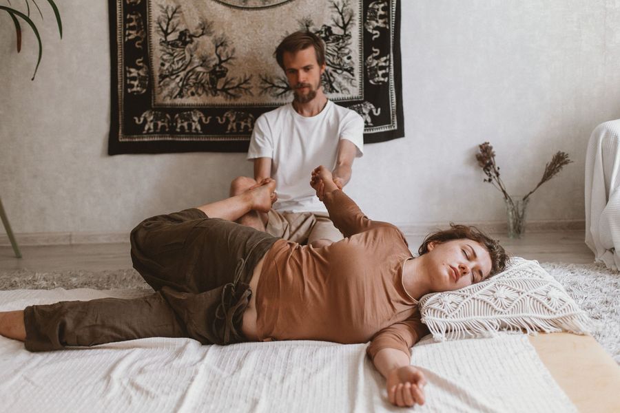 Terapeuta guiando un estiramiento de masaje tailandés
