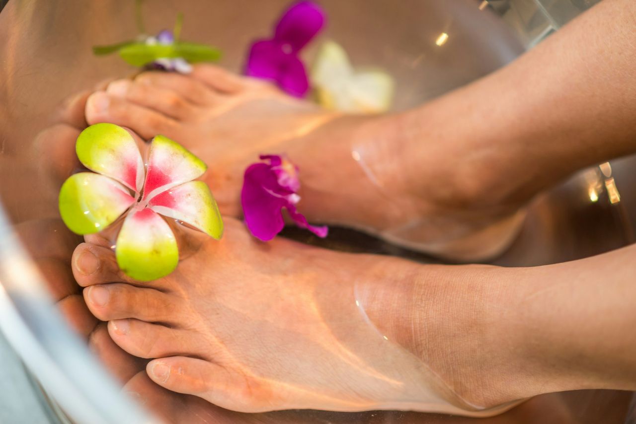 Pies en un baño con flores